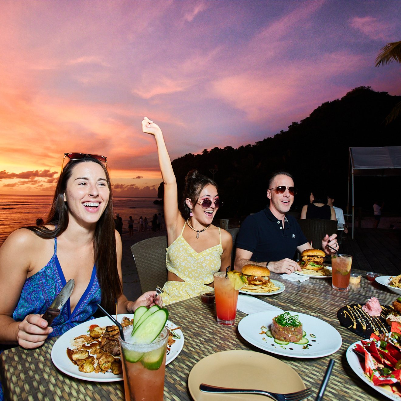a group of people sitting at a table with a plate of food