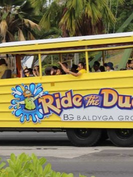 Ride the Ducks boat with happy passengers riding along in Tumon, Guam