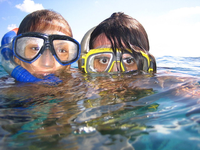 Two boys in water with snorkels and swim-masks