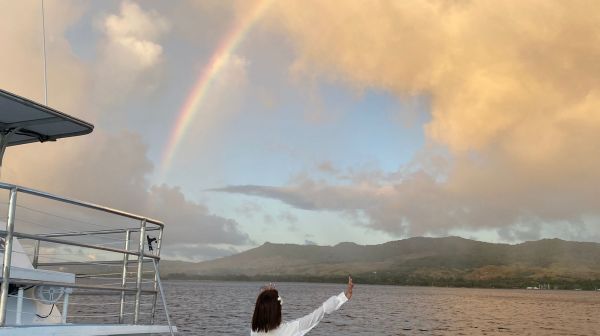 a man standing in front of a boat next to a body of water