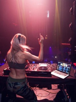 a person sitting on stage with stage lights and an audience