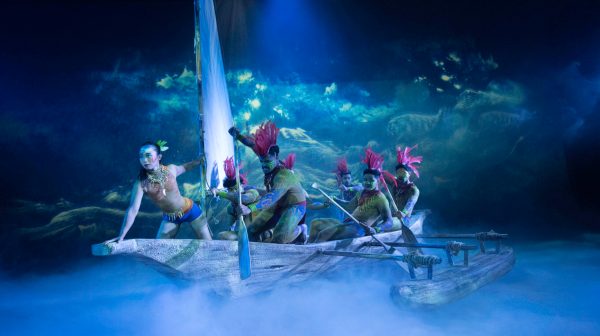 a group of people riding on the back of a boat in the water