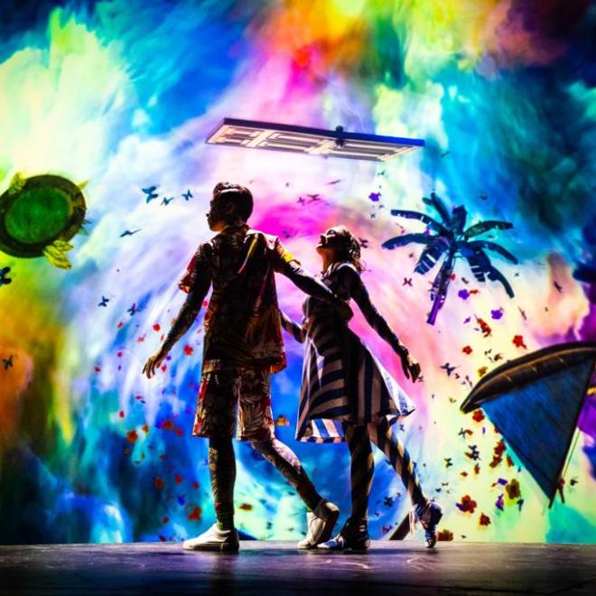 a man on stage with stage lights and an audience