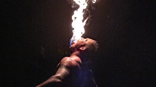 a man standing in front of a fire