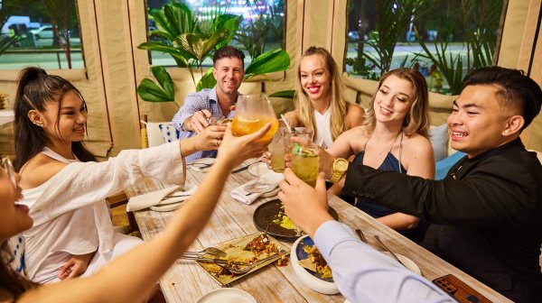 Elizabeth Debicki et al. sitting at a table posing for the camera