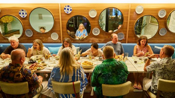 a group of people sitting at a table in front of a store