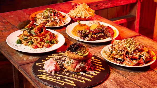 a wooden table topped with plates of food on a plate