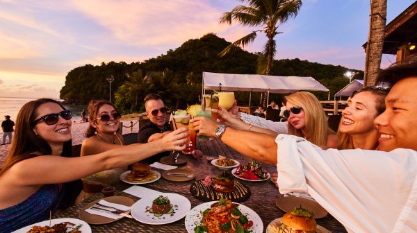 a group of people sitting at a table with a plate of food