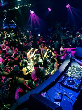a person sitting on stage with stage lights and an audience