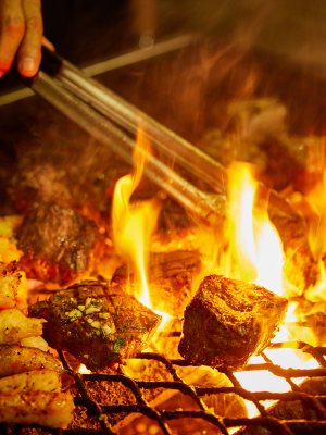 a person cooking hot dogs on a grill