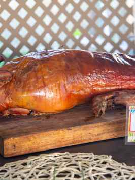 Whole roasted pig on a wooden board labeled 'Roast Pig' in multiple languages.