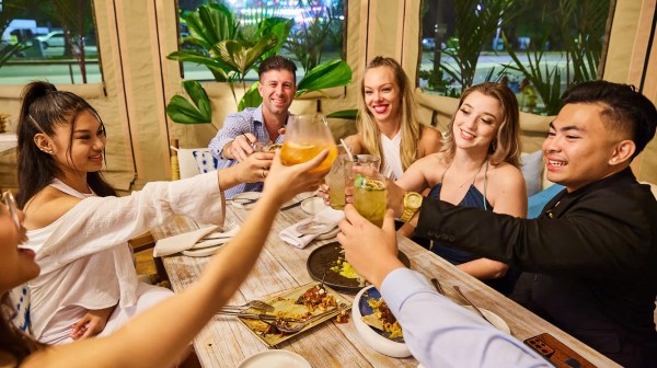 Elizabeth Debicki et al. sitting at a table posing for the camera