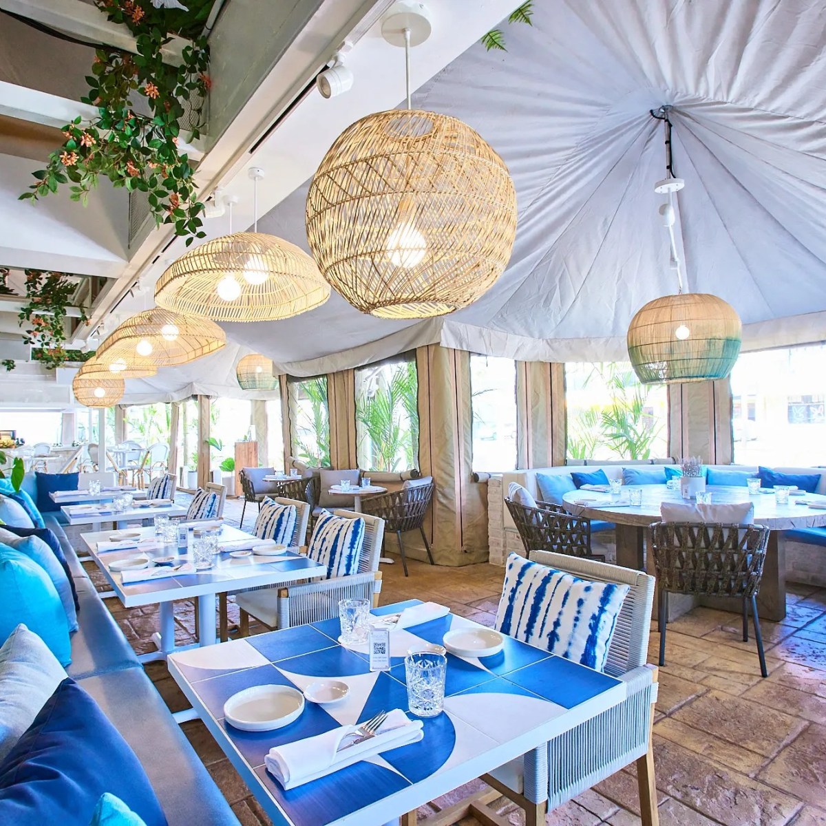 a person sitting at a table with a blue umbrella