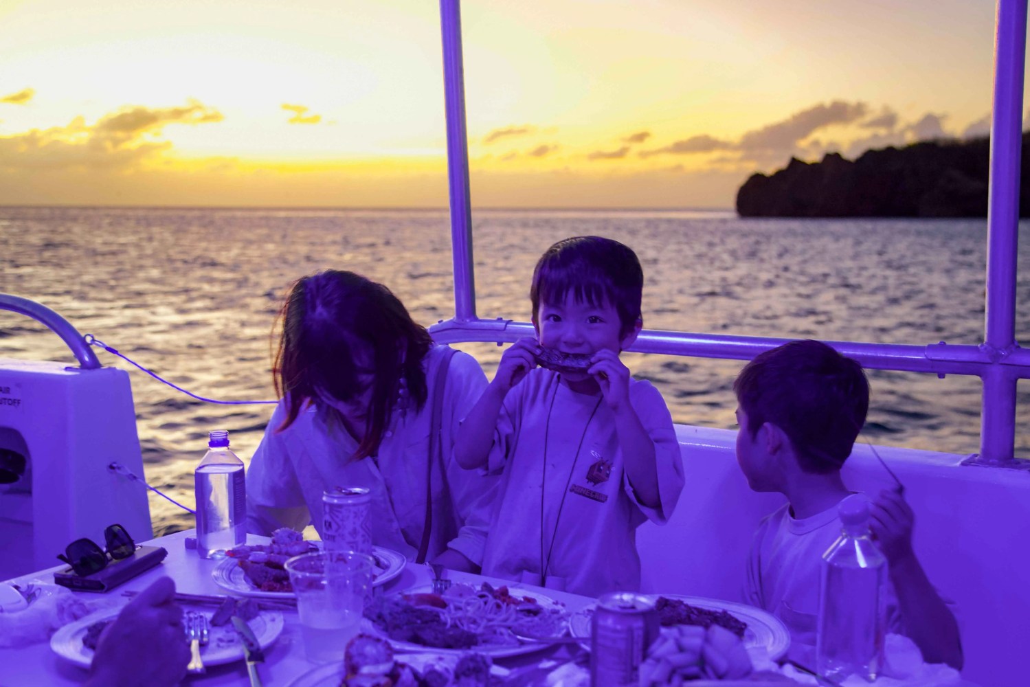 a couple of people that are sitting in front of a body of water
