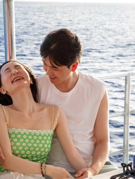 a man and a woman sitting on a boat in the water
