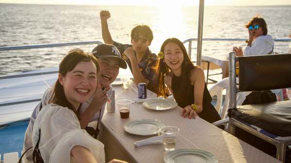 a woman sitting at a table with people in the water