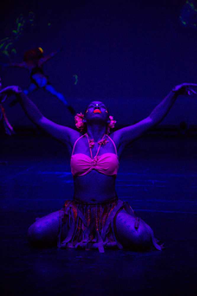 어두운 무대에서 빛나는 카레라 쇼 배우의 화려한 네온 야광 메이크업 퍼포먼스