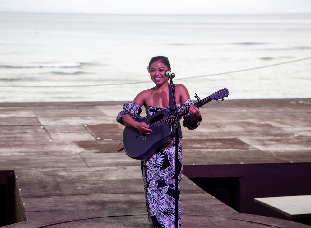 괌 타오타오타씨 디너쇼에서 라이브 공연을 펼치는 가수와 건비치 투몬비치 배경