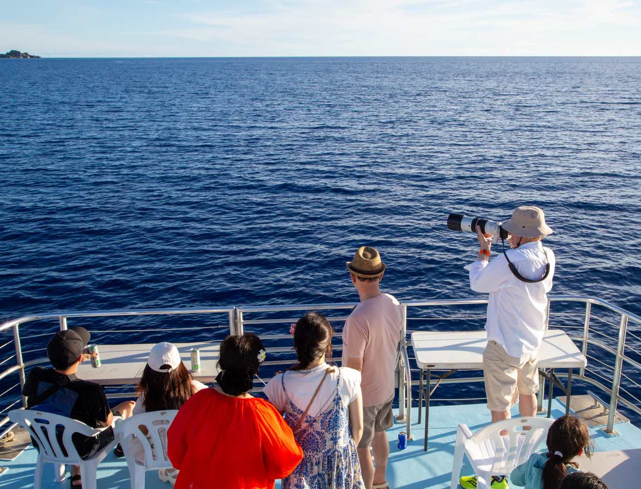 푸른 태평양 바다와 탁 트인 수평선을 배경으로 괌 디너 크루즈를 즐기는 사람들