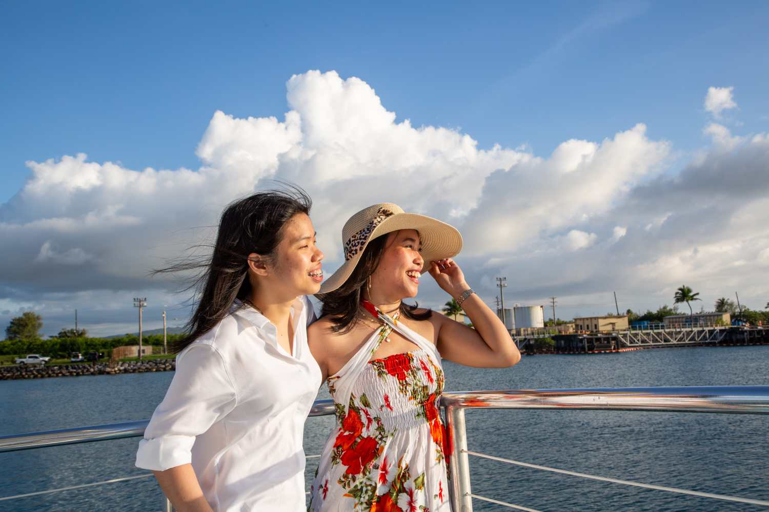 시원한 바닷바람을 맞으며 괌의 환상적인 선셋을 배경으로 사진을 찍는 여성들