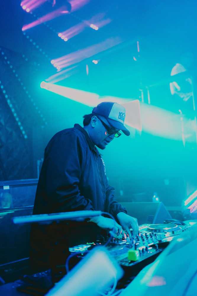 괌 클럽에서 화려한 조명과 함께 음악을 디제잉하는 DJ 퍼포먼스 장면