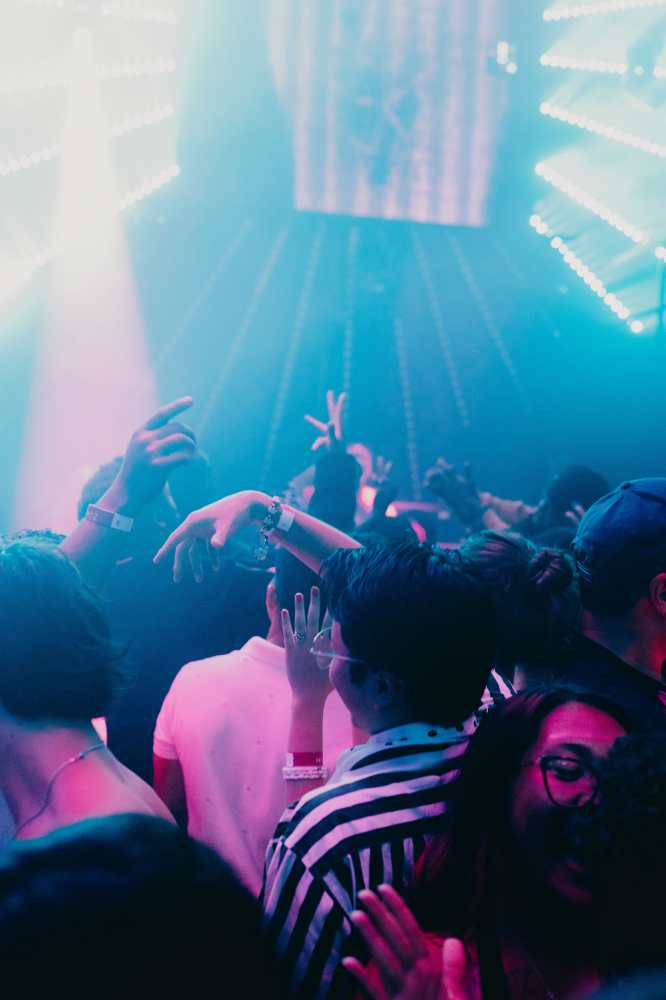 괌 클럽 ZOH의 화려한 조명 아래 파티를 즐기는 역동적인 관객들 모습