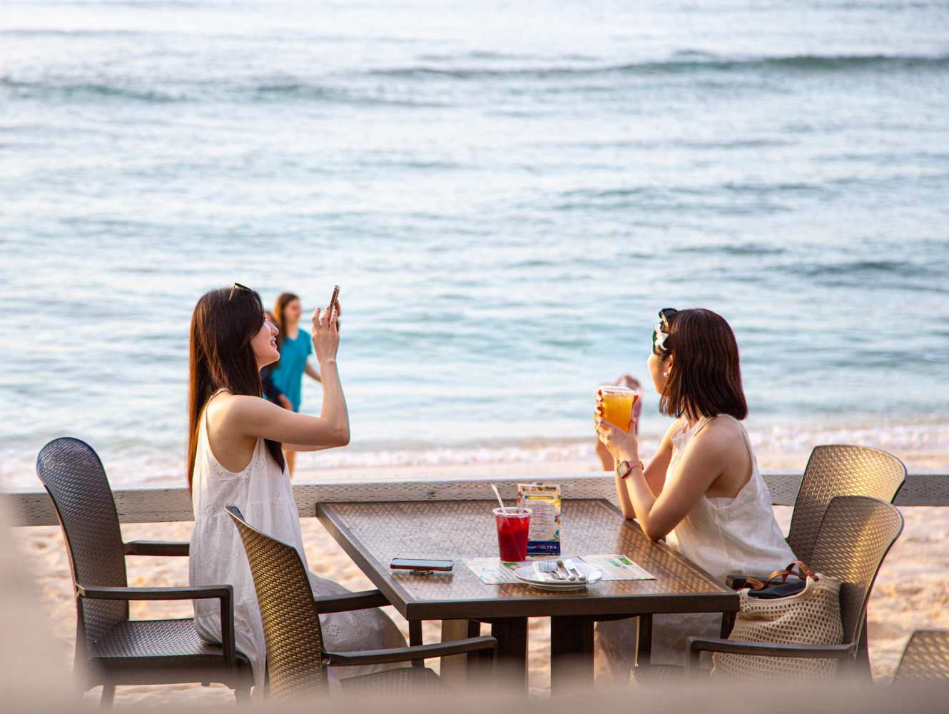 괌 더 비치바에서 아름다운 바다를 바라보며 저녁 식사를 즐기는 여성 관광객들