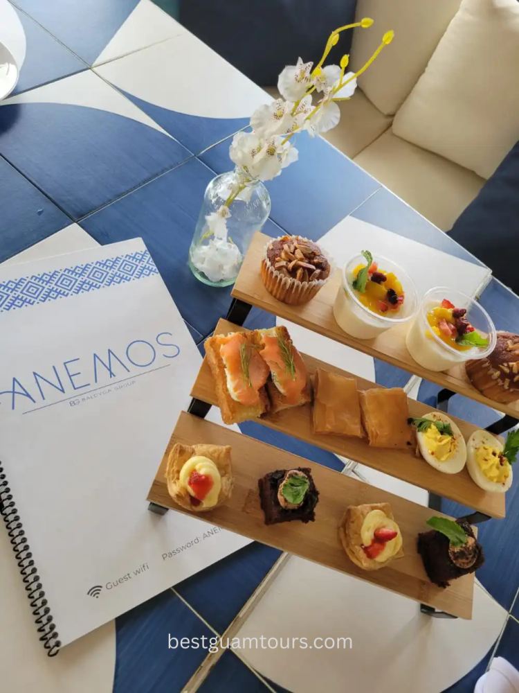 Assorted pastries on a wooden rack next to a menu and flower vase on a table.