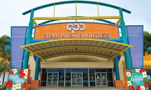 Entrance of Guam Premier Outlets with colorful signage.