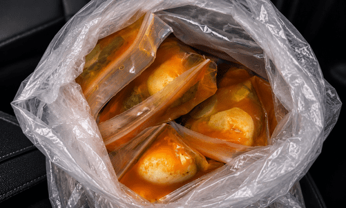 Plastic bag with several plastic pouches containing orange-colored contents.