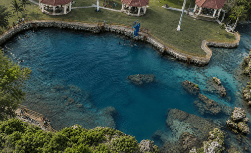 Aerial view of a lagoon surrounded by pavilions and greenery.